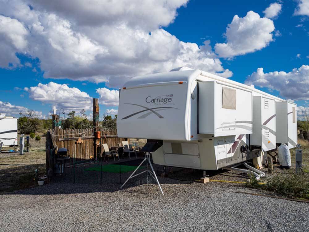 A fifth wheel trailer in a gravel RV site at ROSE VALLEY RV RANCH & CASITAS