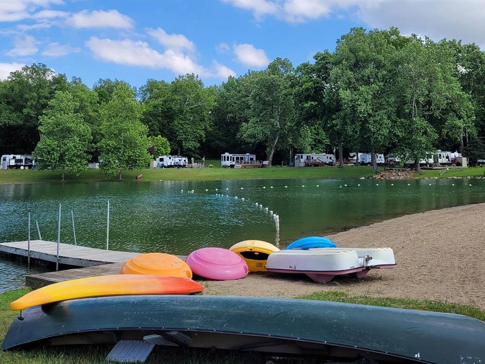 Kayaks and paddleboats next to the lake at MUNCIE RV RESORT BY RJOURNEY