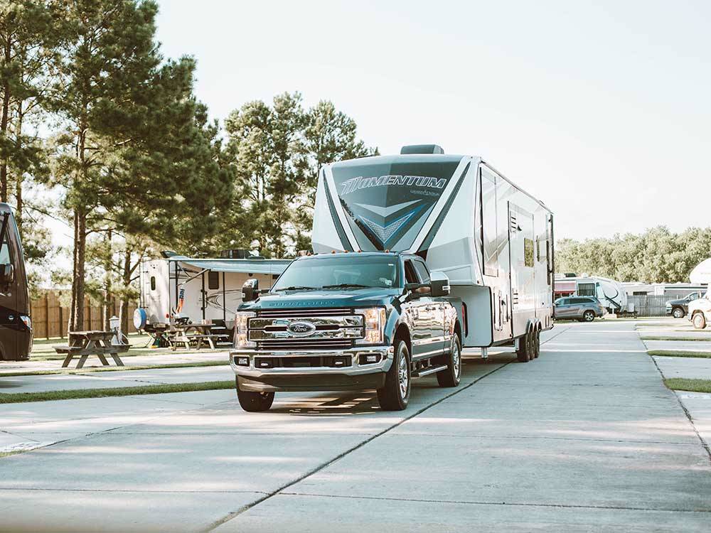 A fifth-wheel trailer pulling thru the park at LAKESIDE RV RESORT BY RJOURNEY