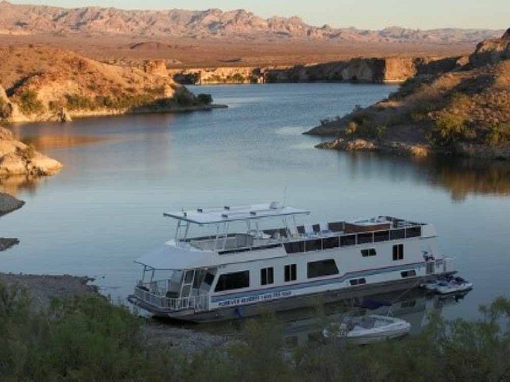 A large houseboat on the water at COTTONWOOD COVE NEVADA RV PARK & MARINA