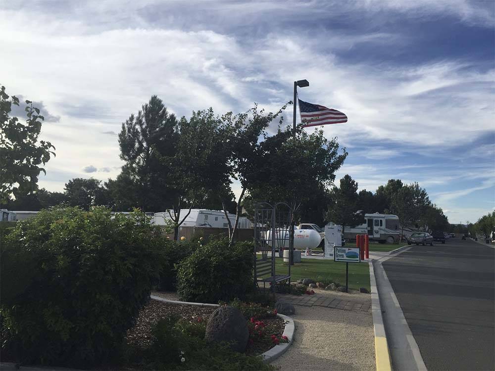 An American flag flies over a campground amid grassy sites at SPARKS MARINA RV PARK