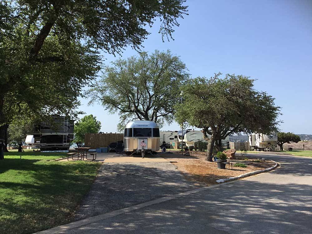 Winding road leading to RVs parked under trees at SUNSET POINT ON LAKE LBJ