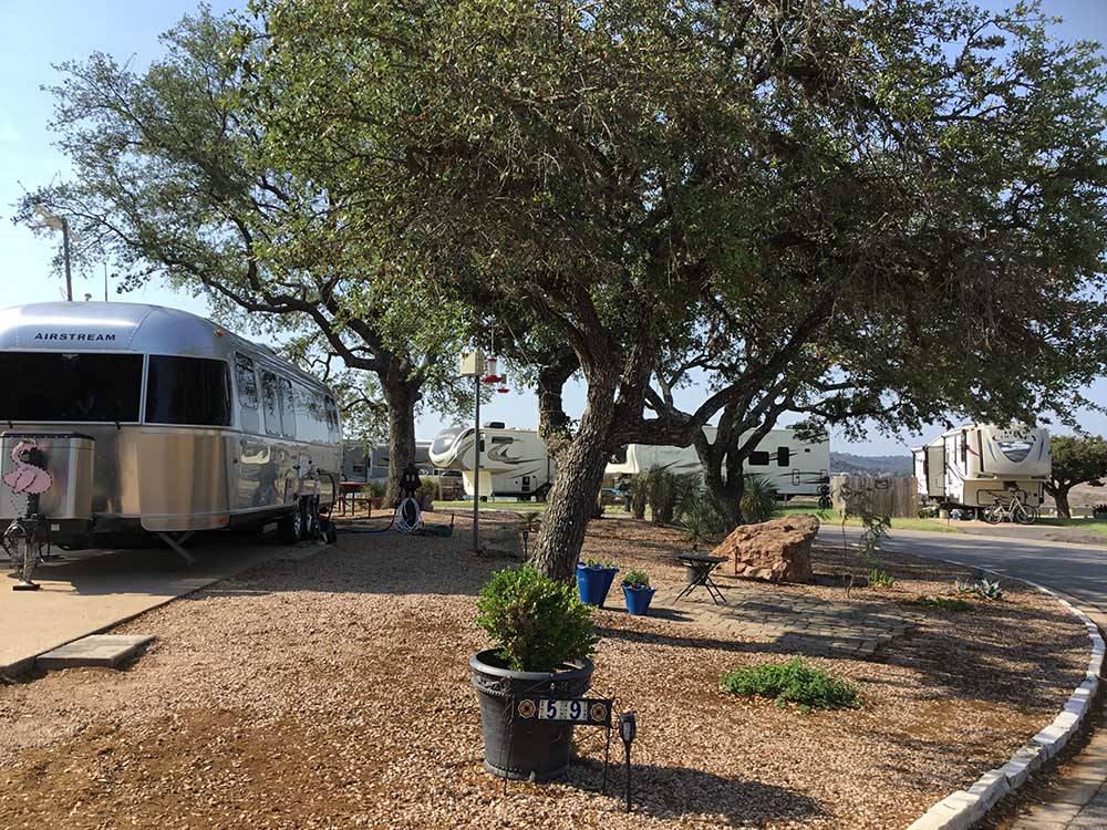An Airstream parked near some trees at SUNSET POINT ON LAKE LBJ