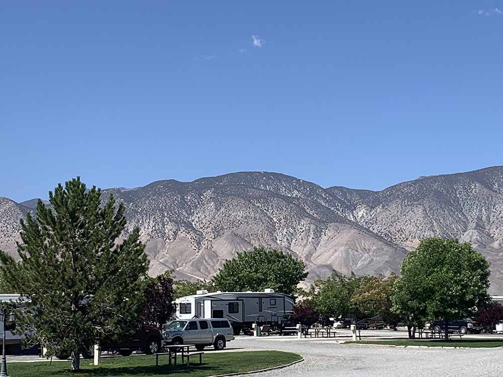 RVs in sites with mountains in the distance at WHISKEY FLATS RV PARK