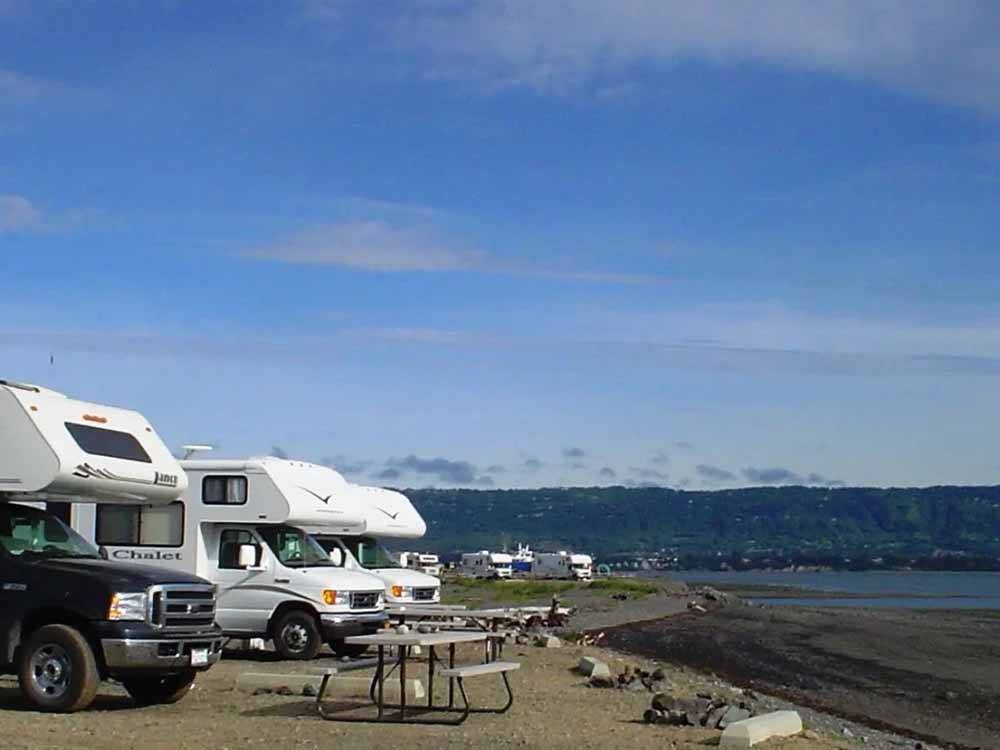 A line of RVs along the water at HERITAGE RV PARK