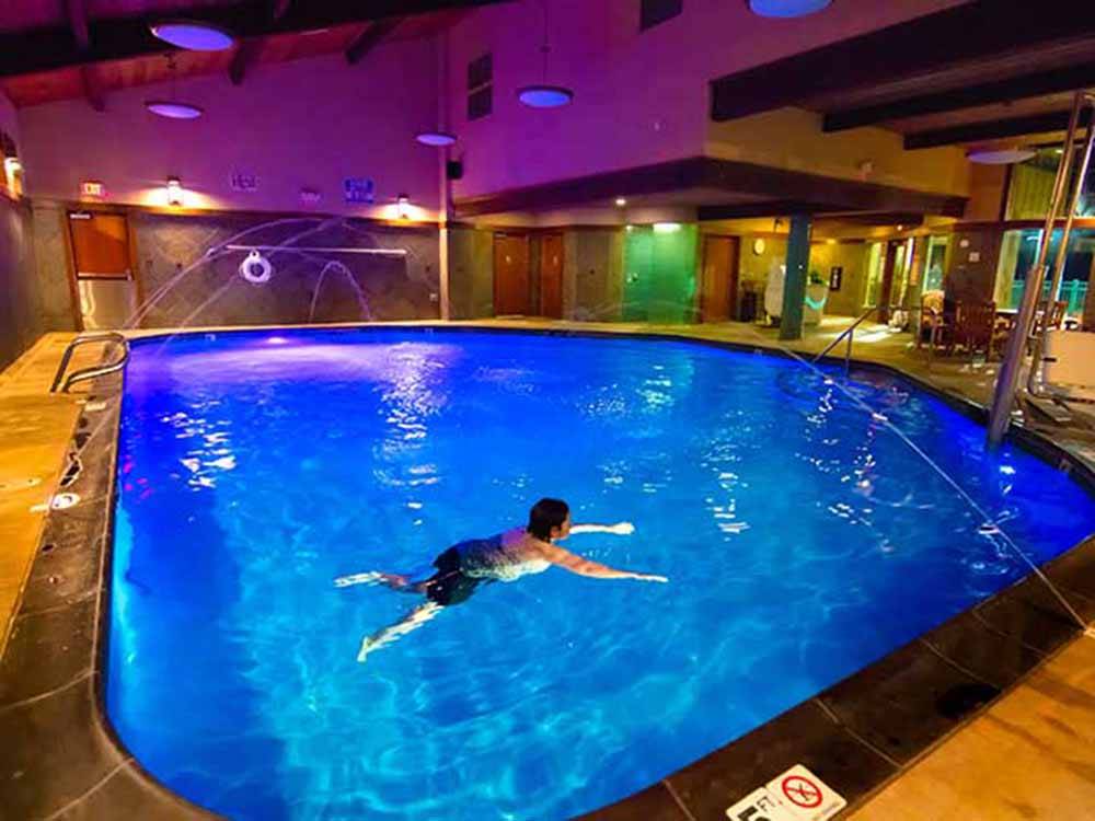 A lady swimming in an indoor swimming pool at THE MILL CASINO HOTEL & RV PARK