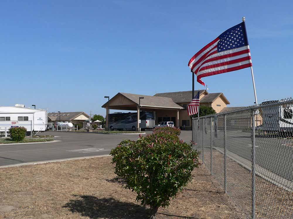 American flags waving on fence in front of office at FLAG CITY RV RESORT