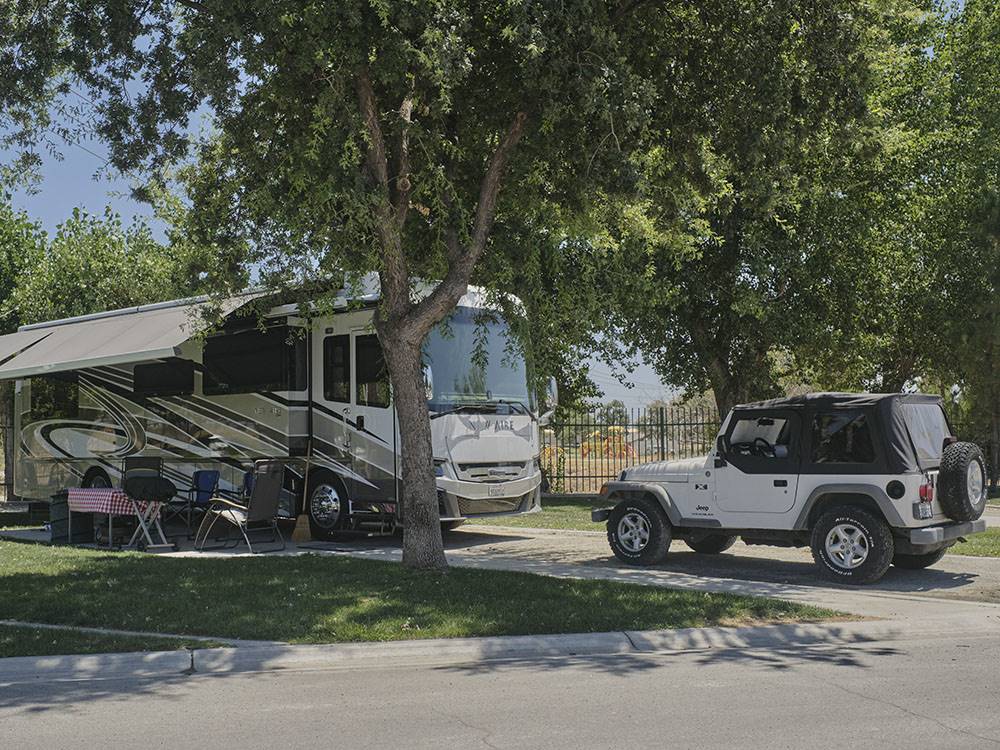 A class A motorhome and Jeep in a back in site at BAKERSFIELD RIVER RUN RV PARK