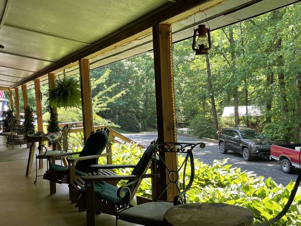 The covered porch on the office with chairs at SOLITUDE POINTE CABINS & RV PARK