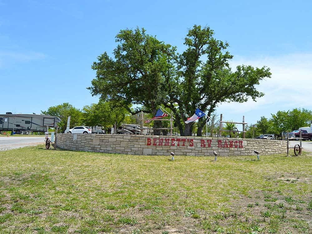 Flags waving over entry sign at BENNETT'S RV RANCH
