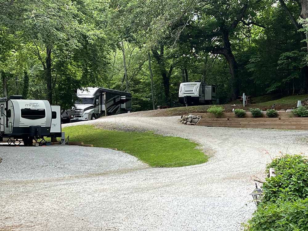 A road going up to RV sites at A motorhome in a gravel RV site with a patio at FRANKLIN RV PARK & CAMPGROUND