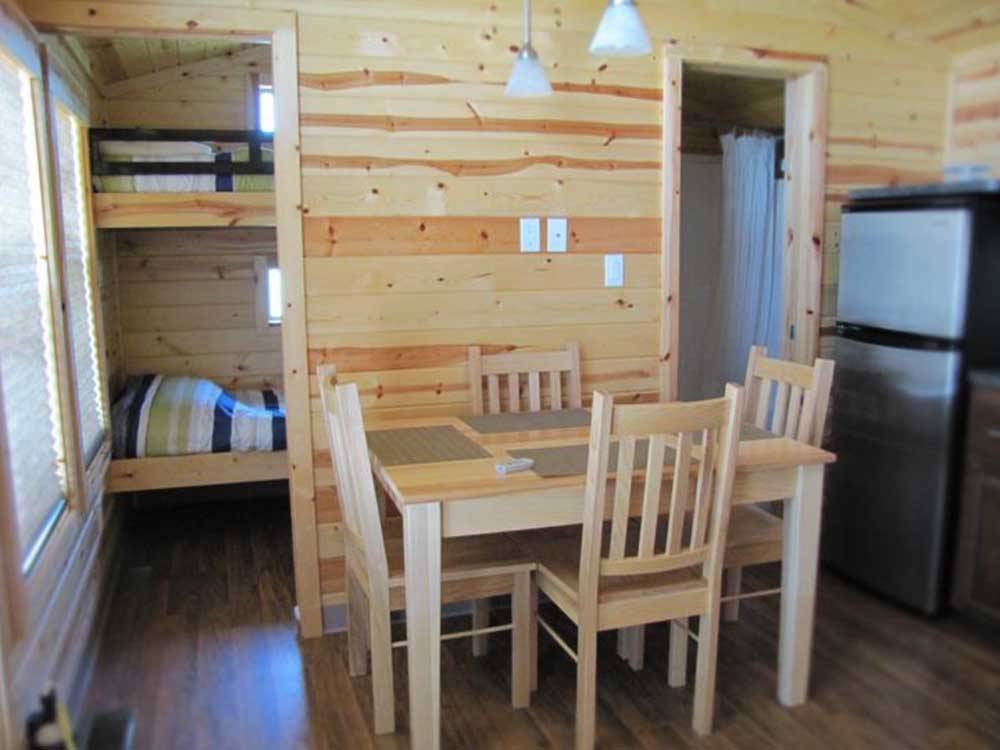 Dining area and bunk beds in cabin at CAMPING POKEMOUCHE