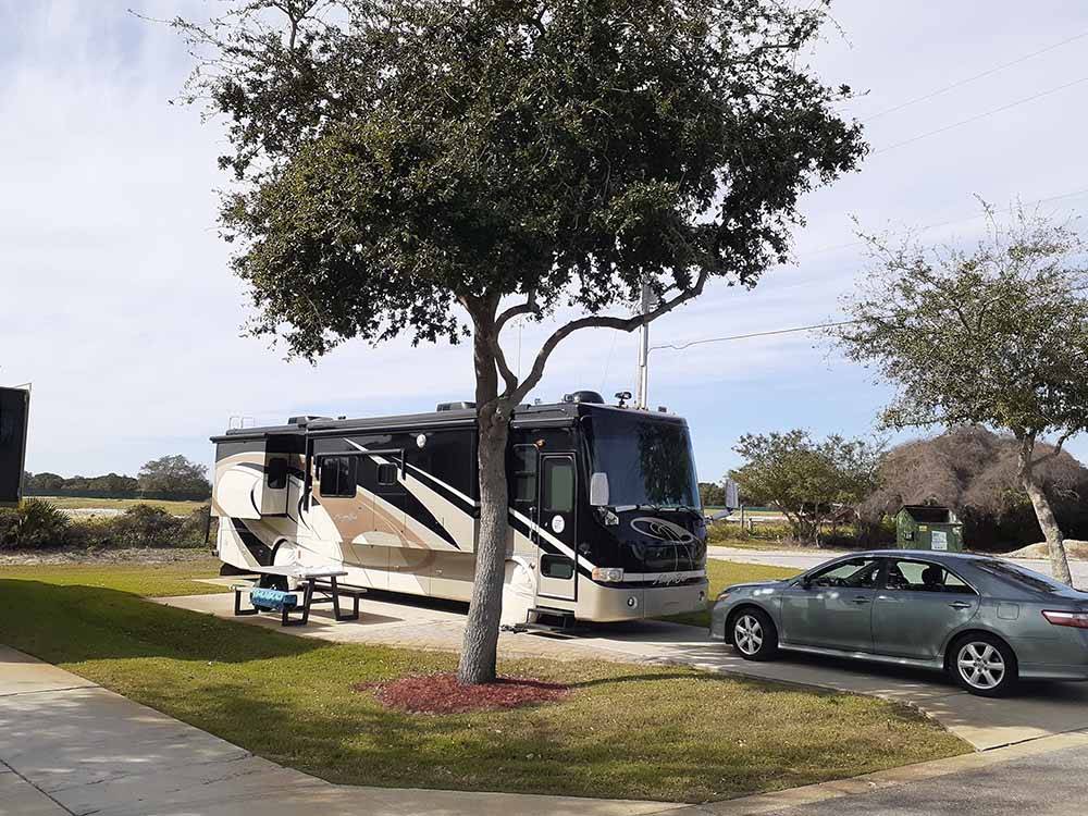 A motorhome in a back in paved RV site at GERONIMO RV PARK