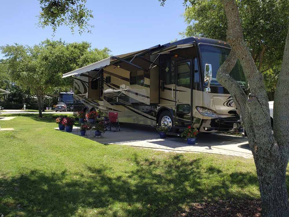 A brown motorhome parked in one of the paved RV sites at GERONIMO RV PARK