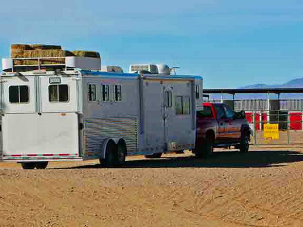 A red truck pulling a horse trailer at KIVA RV PARK & HORSE MOTEL