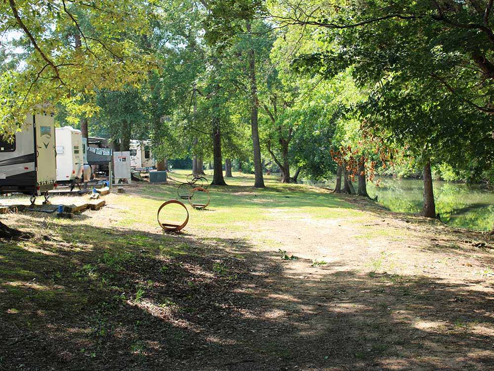 Row of waterfront sites with trailers at CEDAR CREEK RV & OUTDOOR CENTER