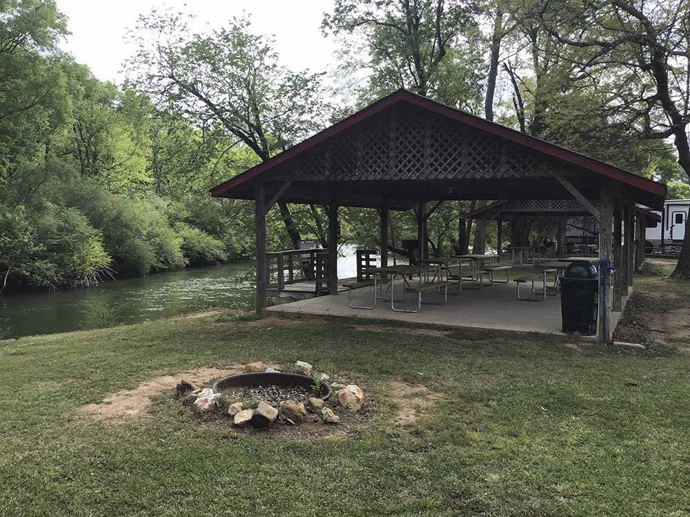 A covered pavilion by the river at CEDAR CREEK RV & OUTDOOR CENTER