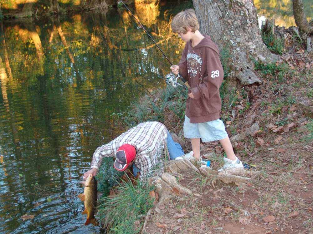A family fishing in the river at CEDAR CREEK RV & OUTDOOR CENTER