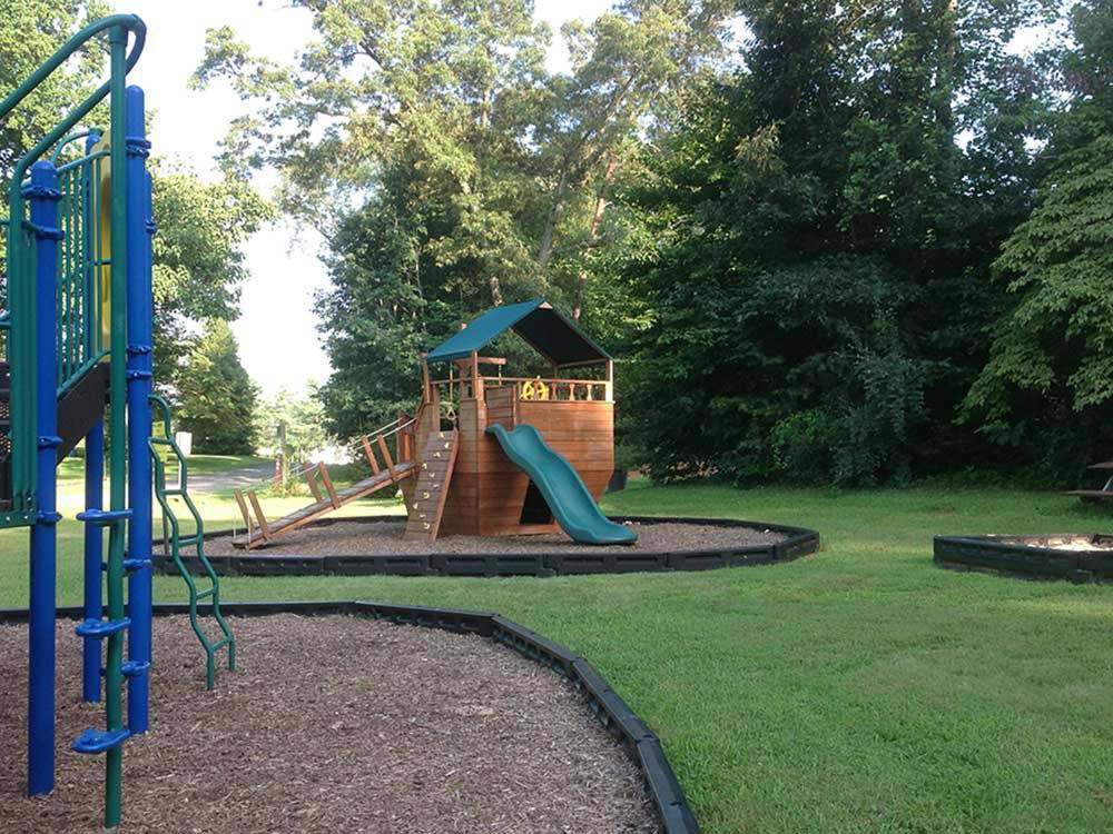 Playground with wooden-ship play structure at MADISON VINES RV RESORT & COTTAGES