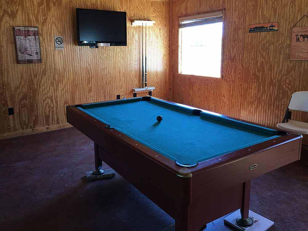 A pool table and TV in the rec room at COFFEE CREEK RV RESORT & CABINS