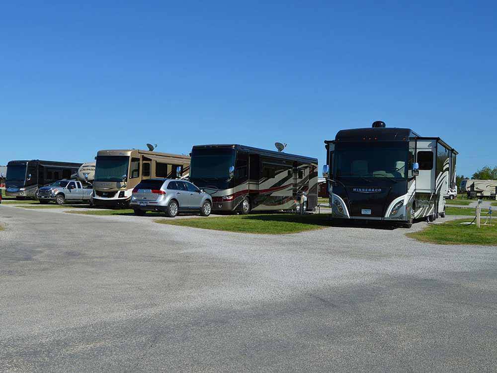 RVs in paved back-in sites with bright blue skies at COFFEE CREEK RV RESORT & CABINS