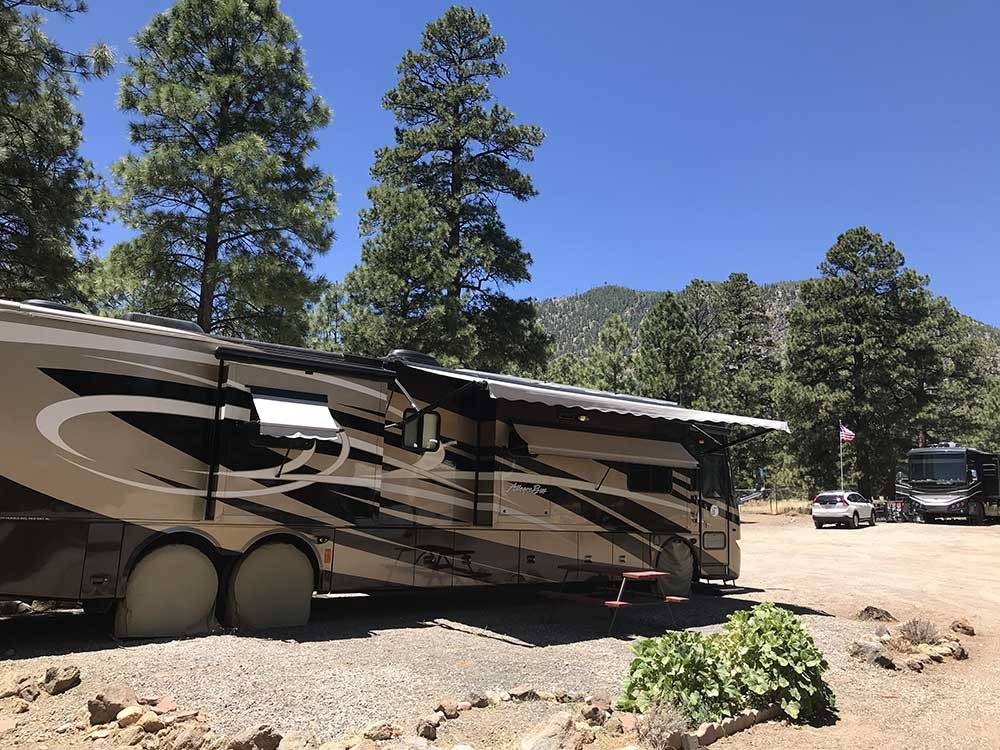 A large motorhome with it's awning out at FLAGSTAFF RV PARK