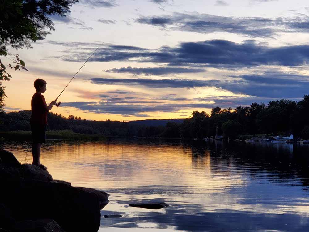 A boy fishing in the morning at SID TURCOTTE PARK CAMPING AND COTTAGE RESORT