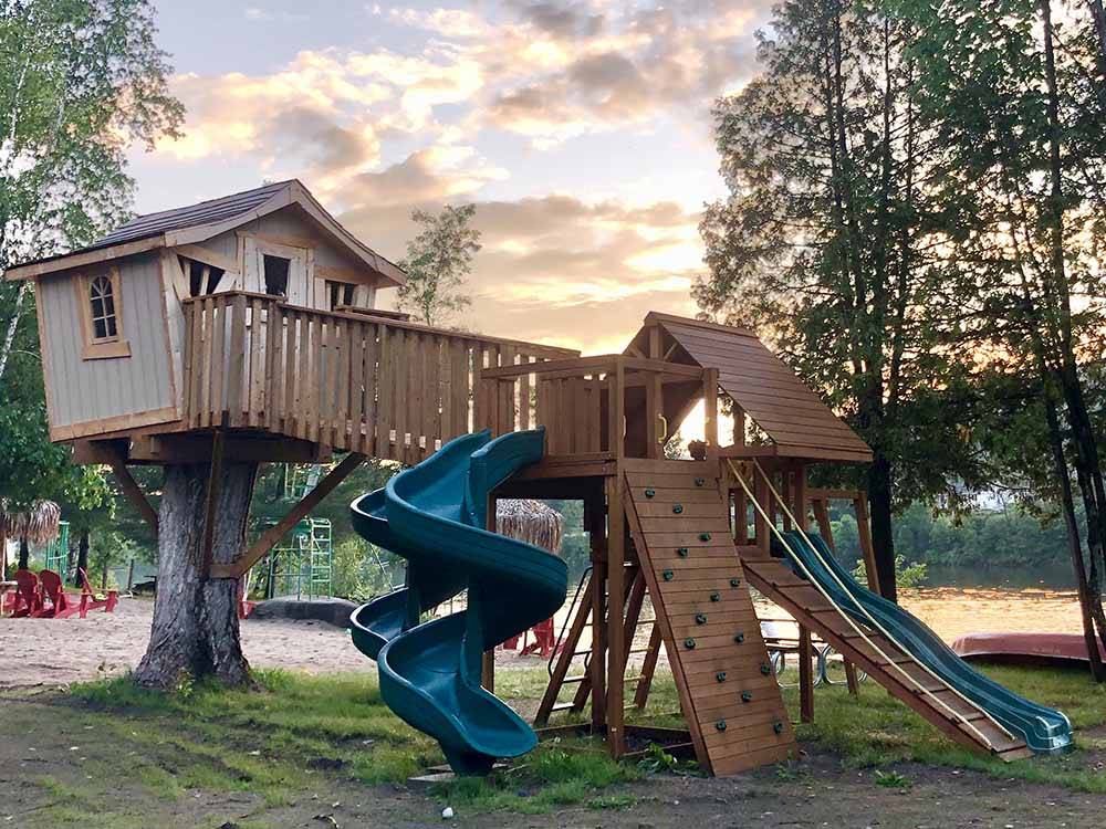 A playground with a tree house at SID TURCOTTE PARK CAMPING AND COTTAGE RESORT