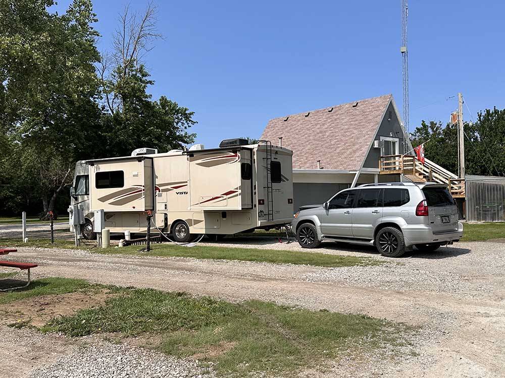 A motorhome and a SUV parked in a pull thru site at ALL SEASONS RV PARK