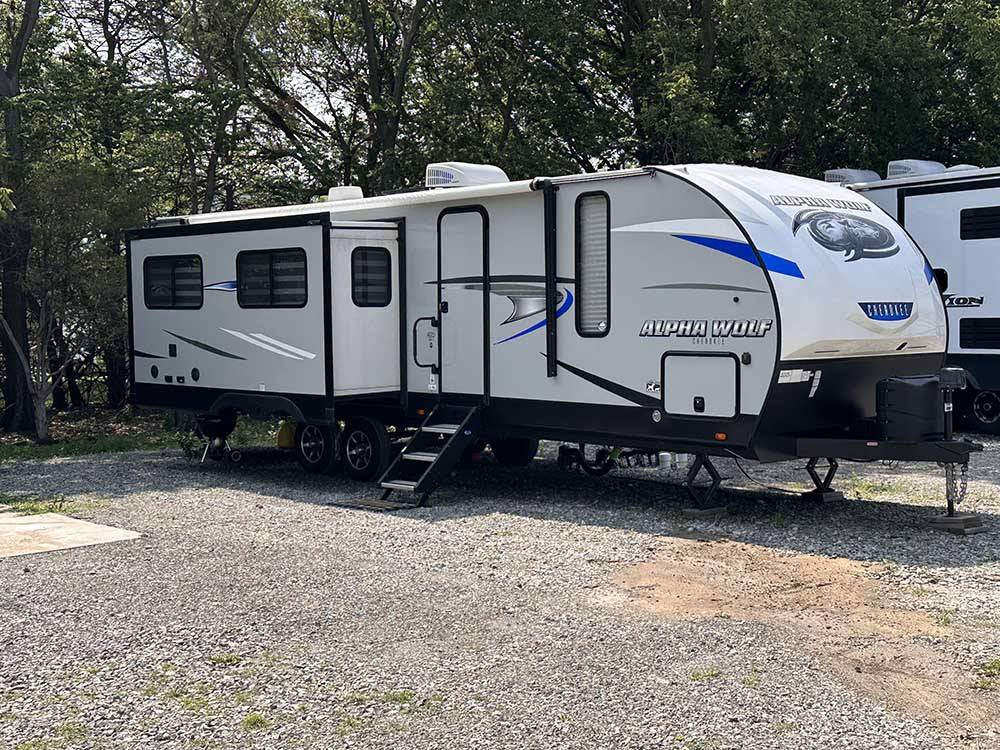 A travel trailer parked in a back in site at ALL SEASONS RV PARK