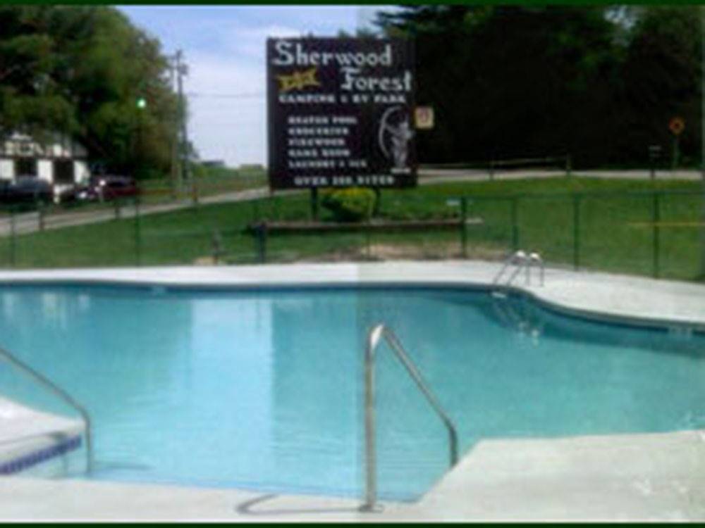 A view of the swimming pool with the park sign at SHERWOOD FOREST CAMPING & RV PARK
