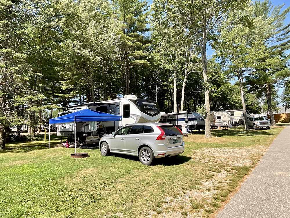 Camping on grassy sites under tall trees at SEA-VU CAMPGROUND