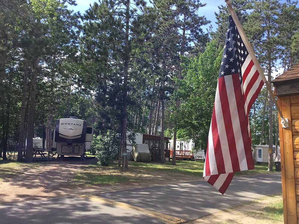 USA flag with RVs parked in sites at STONY POINT RESORT RV PARK & CAMPGROUND