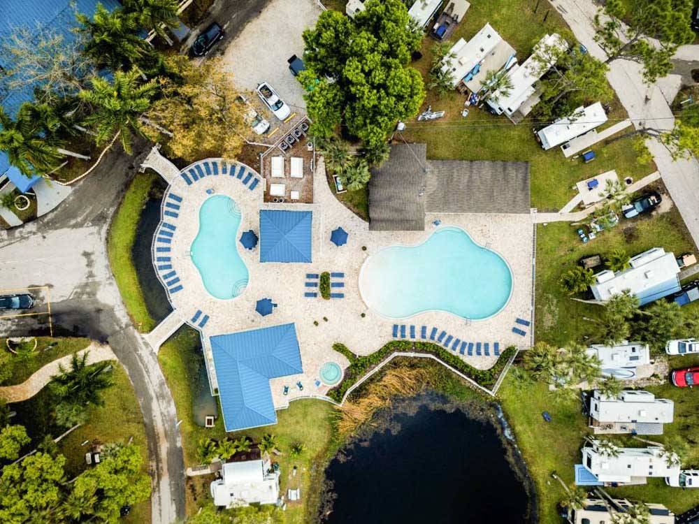 Aerial view of pool near RVs parked in lush sites at BLUEWAY RV VILLAGE