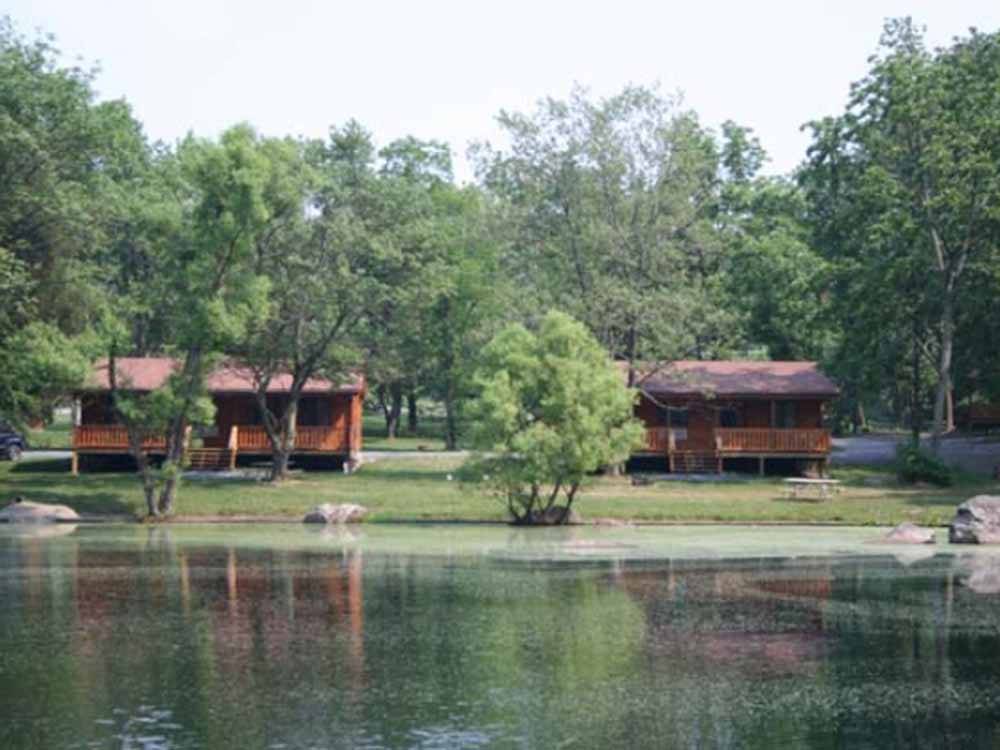 A couple of camping cabins by the water at DRUMMER BOY CAMPING RESORT