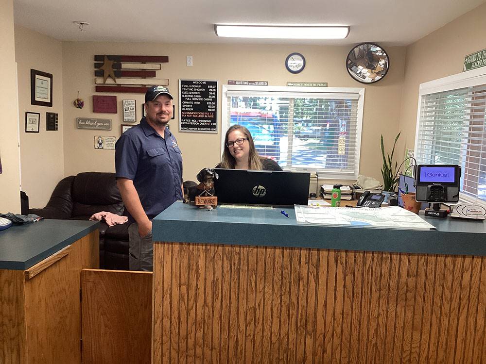 A man and lady at the registration desk at ROCKY MOUNTAIN 'HI' RV PARK AND CAMPGROUND