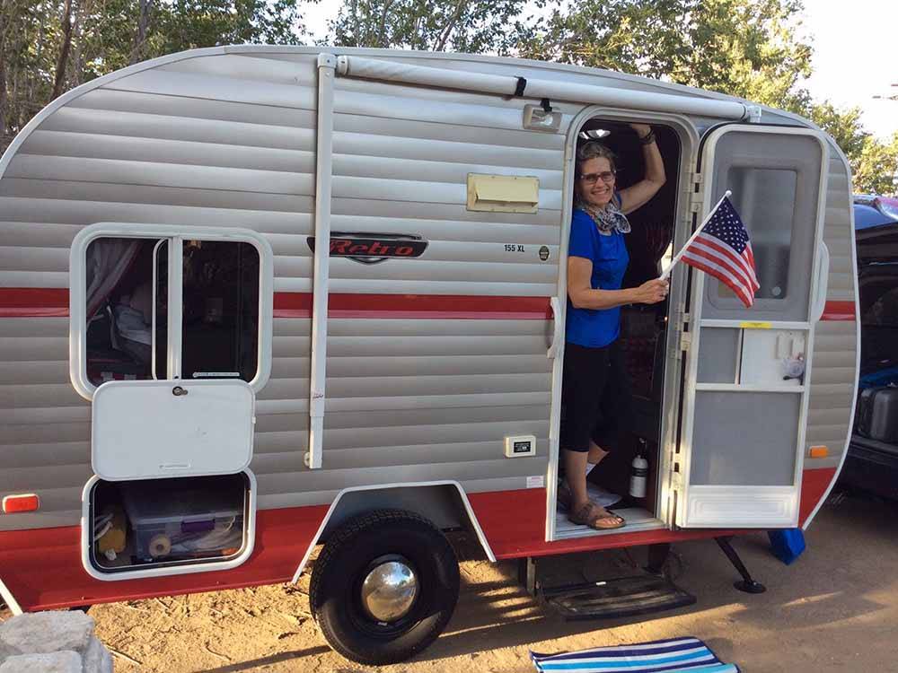 A woman standing in the doorway of a trailer at LAKE ISABELLA RV RESORT