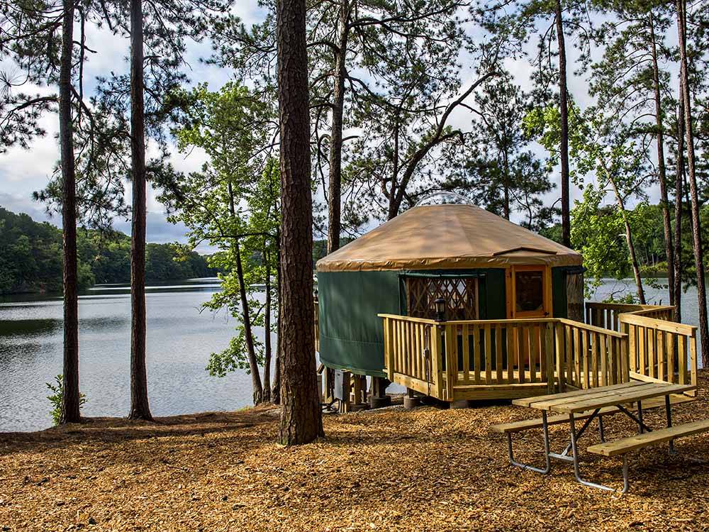 A yurt set up by the river at STONE MOUNTAIN PARK CAMPGROUND