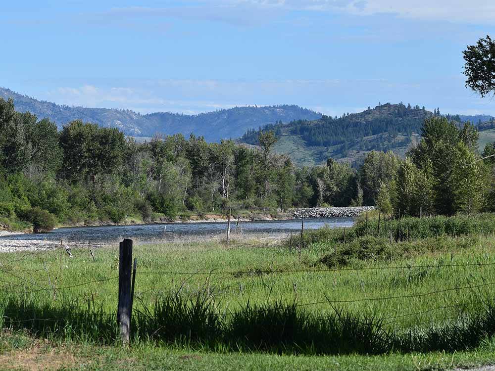 A green field by the river at RIVERBEND RV PARK OF TWISP