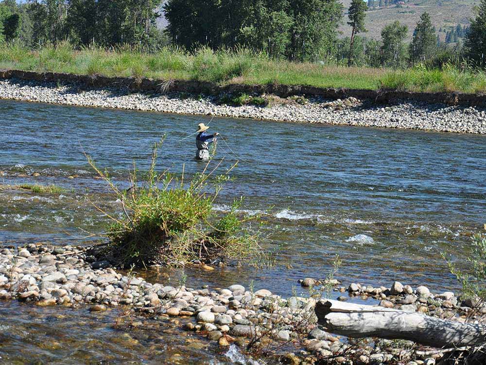 A person standing in the river fishing at RIVERBEND RV PARK OF TWISP