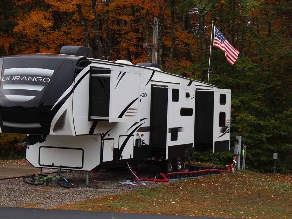 A fifth wheel trailer parked in a RV site at JELLYSTONE PARK ™ AT BIRCHWOOD ACRES