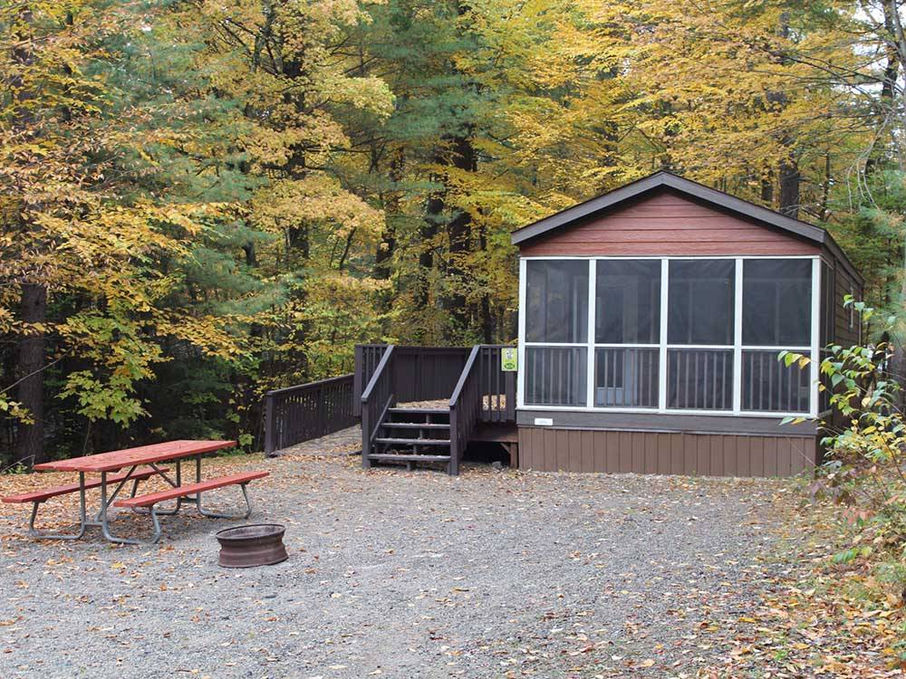A rental cabin with a bench and fire pit at JELLYSTONE PARK ™ AT BIRCHWOOD ACRES