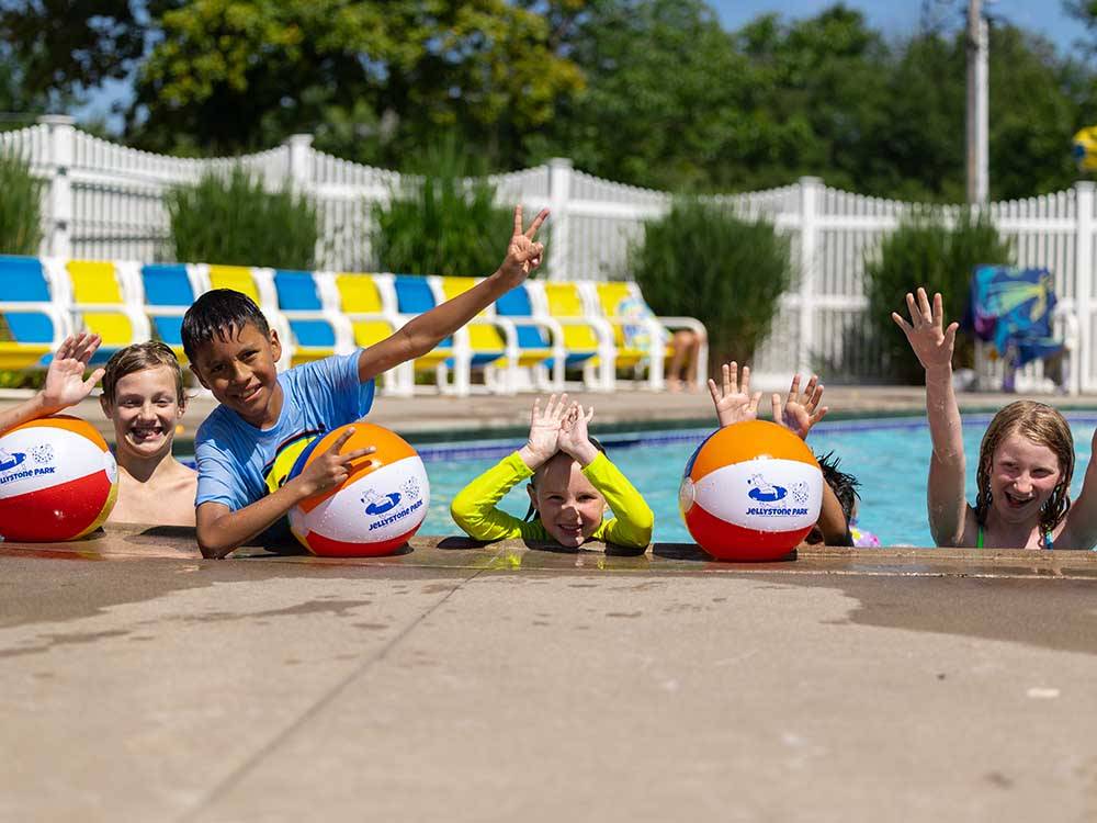 A group of kids in the swimming pool at JELLYSTONE PARK ™ AT BIRCHWOOD ACRES