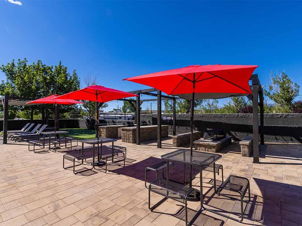 Tables with red umbrellas at COMSTOCK COUNTRY RV RESORT