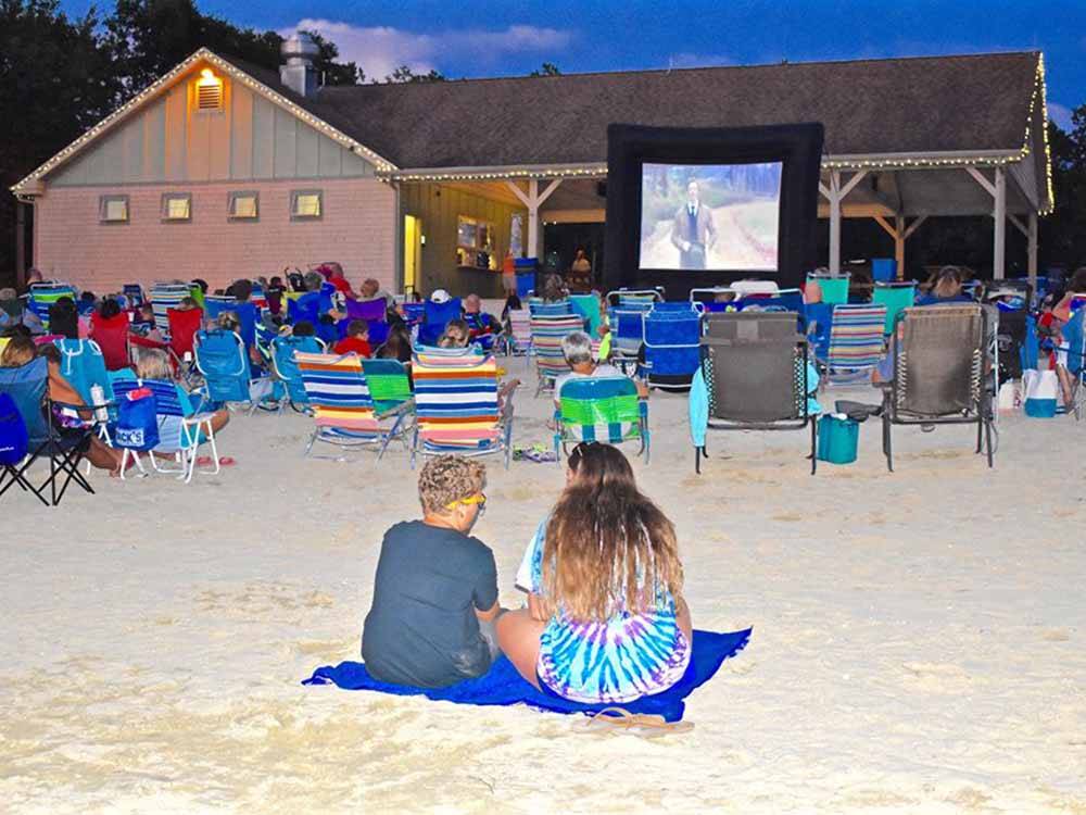 People sitting on the beach watching a movie at OCEAN VIEW RESORT CAMPGROUND