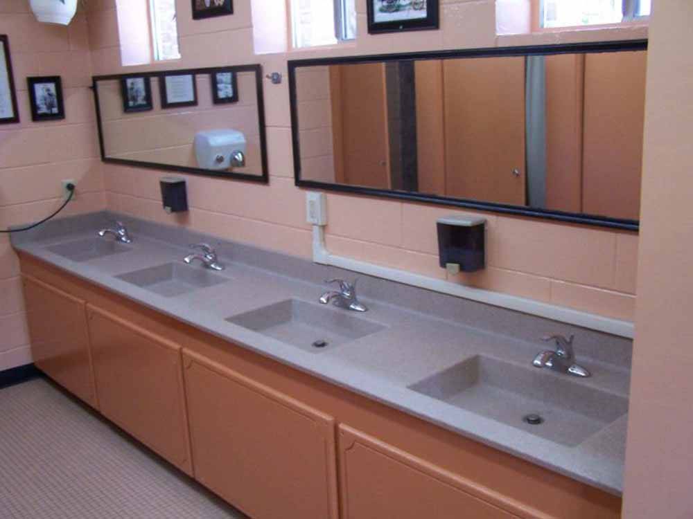 Row of clean sinks in public bathroom at FORT SMITH-ALMA RV PARK
