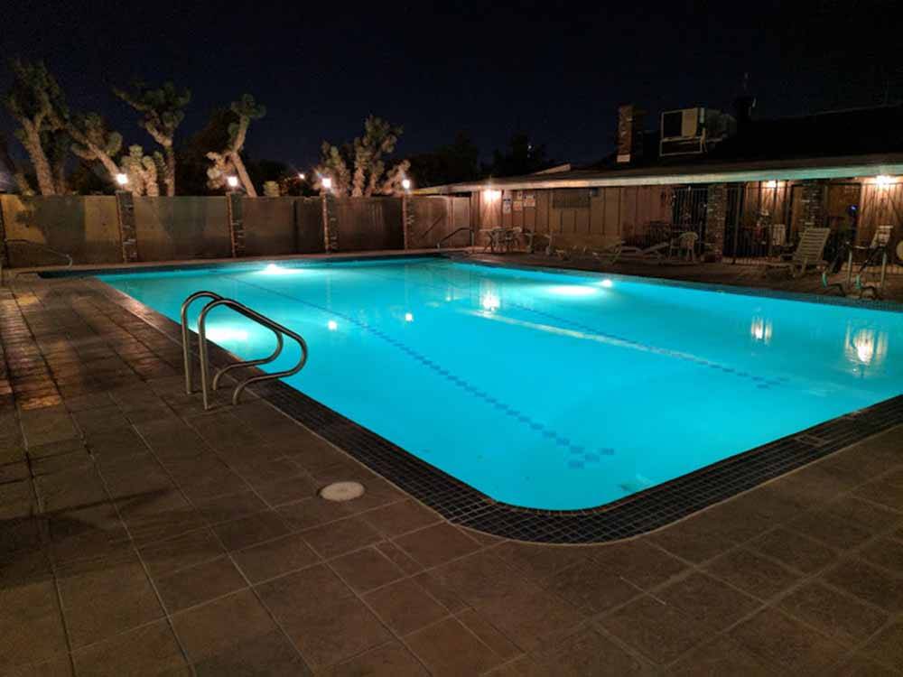 Lit up pool at nighttime at HITCHIN' POST RV PARK