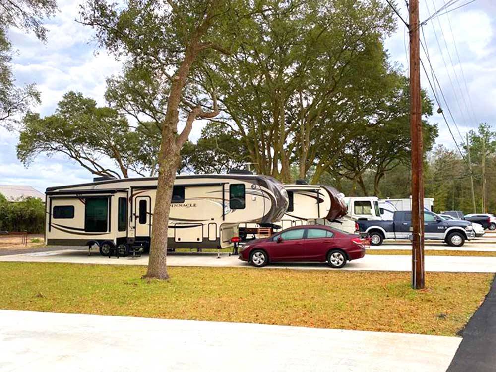 Travel trailers and cars in paved sites at I-10 KAMPGROUND