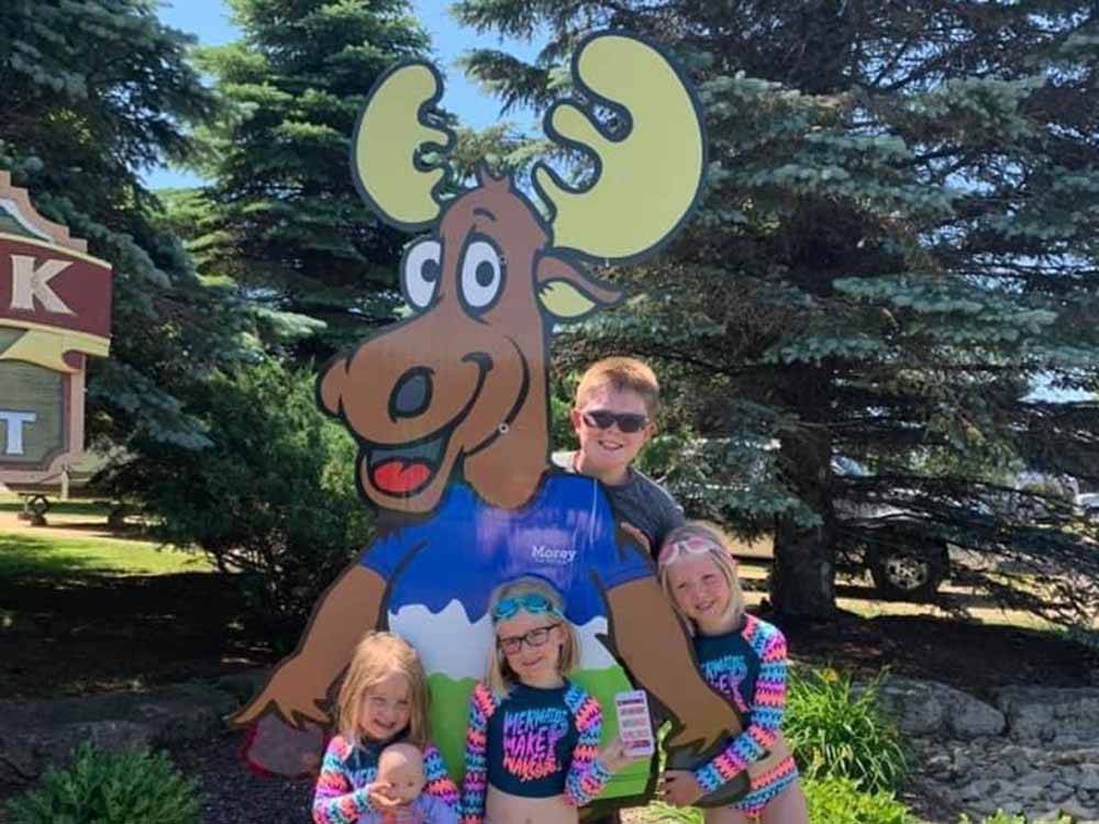 Kids standing around a cut out of a moose at STONEY CREEK RV RESORT