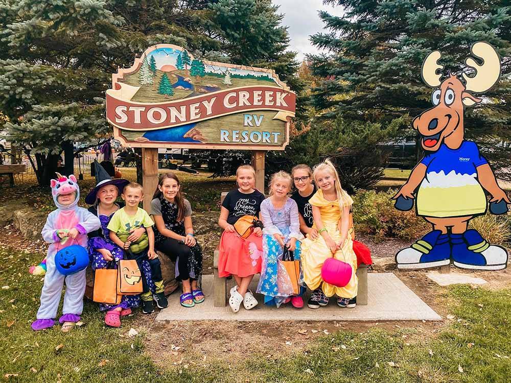 A group of kids around the front entrance sign at STONEY CREEK RV RESORT